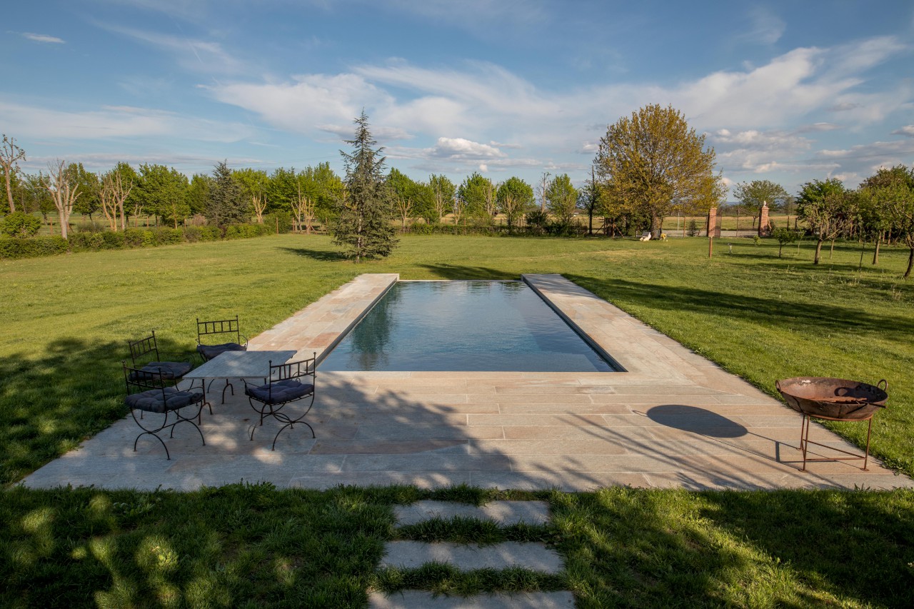 Piscina interrata con sfioro infinito e spiaggia